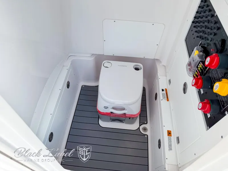 Slide: The Image of 2025 Caymas 281 HB boat interior with portable toilet and control panel. - 13