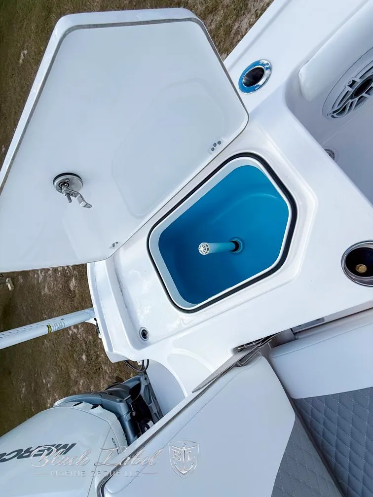 Slide: The Image of 2025 Caymas 281 HB boat with open storage compartment and visible engine. - 27