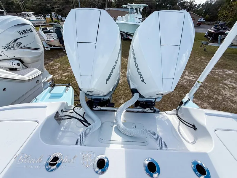 Slide: The Image of 2025 Caymas 281 HB boat with dual Mercury outboard engines, docked outdoors. - 28