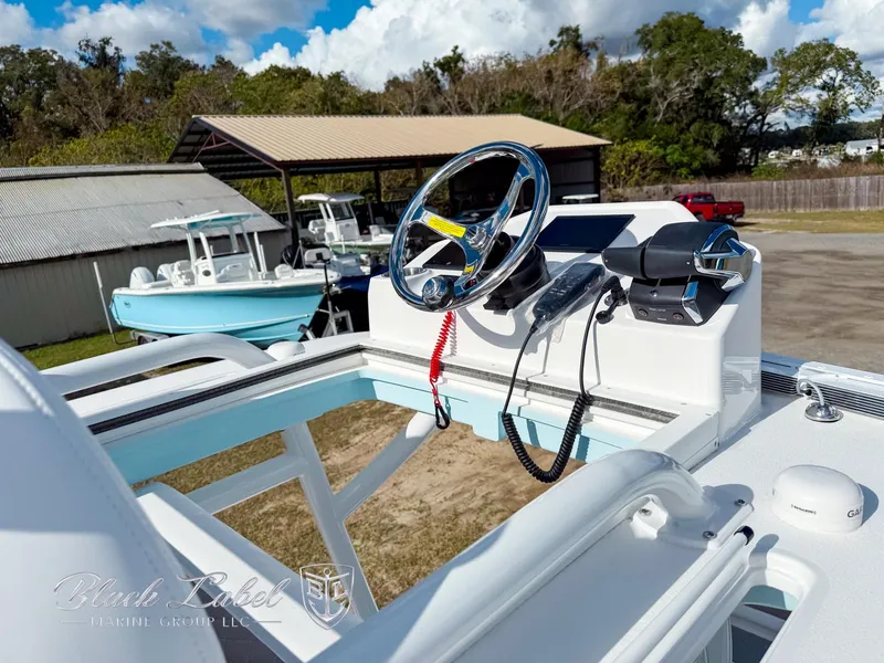 Slide: The Image of 2025 Caymas 281 HB boat helm with steering wheel and controls, parked outdoors. - 33