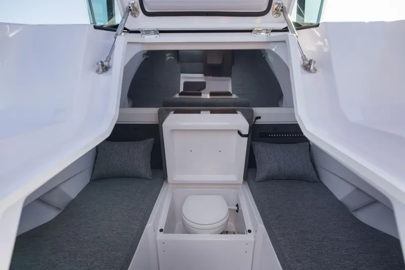 Slide: The Image of 2025 Axopar 29 XC cabin interior with seating and compact toilet. - 13
