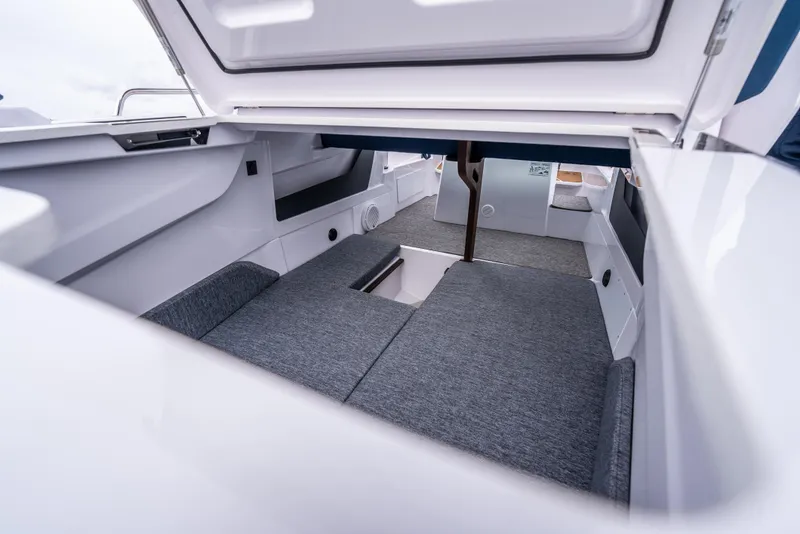 Slide: The Image of 2025 Axopar 29 XC cabin interior with gray seating and storage compartments. - 15