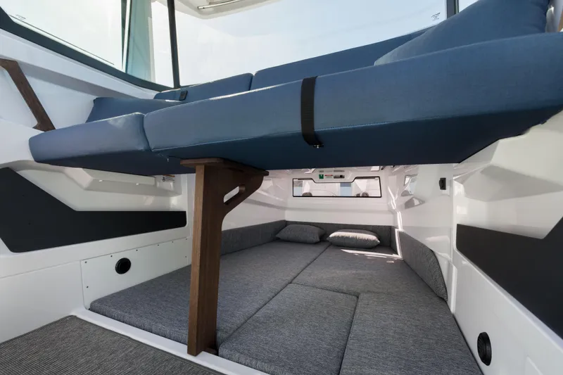 Slide: The Image of Interior cabin of 2025 Axopar 29 XC boat with blue seating and gray bedding. - 17