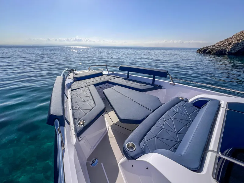 Slide: The Image of 2025 Axopar 29 XC boat with luxurious seating on calm blue waters. - 6
