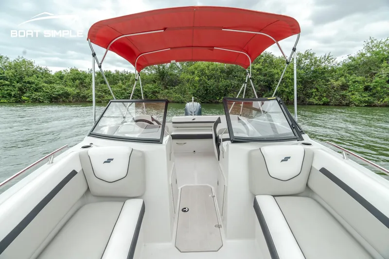 Slide: The Image of 2024 Starcraft SVX 190 OB DC boat with red canopy on a serene lake. - 9