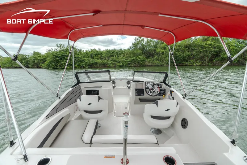 Slide: The Image of 2024 Starcraft SVX 190 OB DC boat interior with red canopy on a lake. - 6