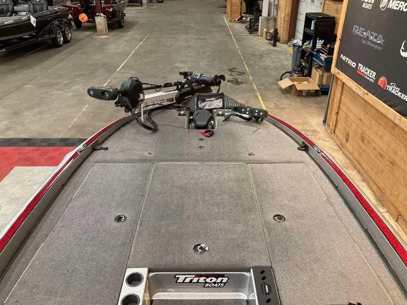 Slide: The Image of 2017 Triton 21 TrX boat deck with fishing equipment in a showroom. - 8