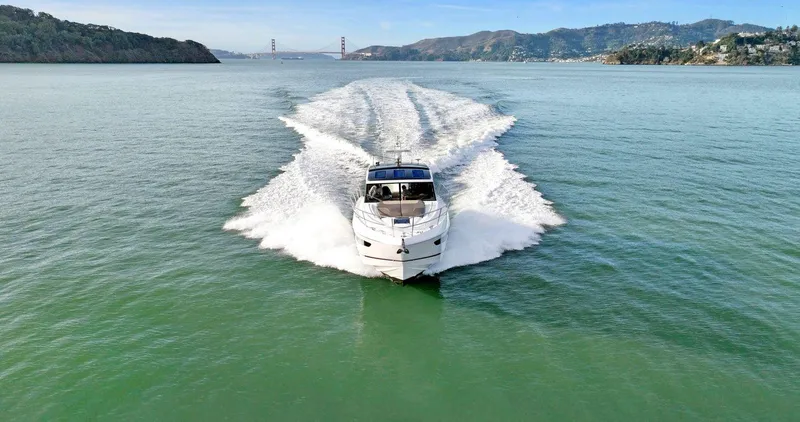 Slide: The Image of 2019 Princess V50 yacht cruising on open water with scenic backdrop. - 9
