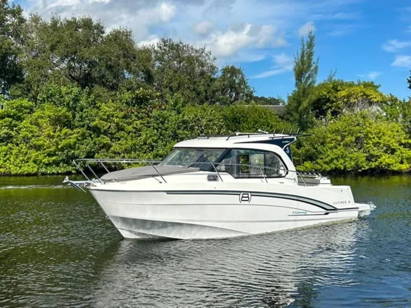 Slide: The Image of 2023 Beneteau Antares 8 boat cruising on a serene river with lush greenery. - 0