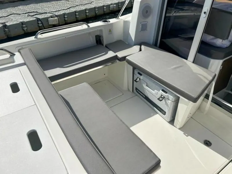 Slide: The Image of 2023 Beneteau Antares 8 boat seating area with gray cushions. - 12