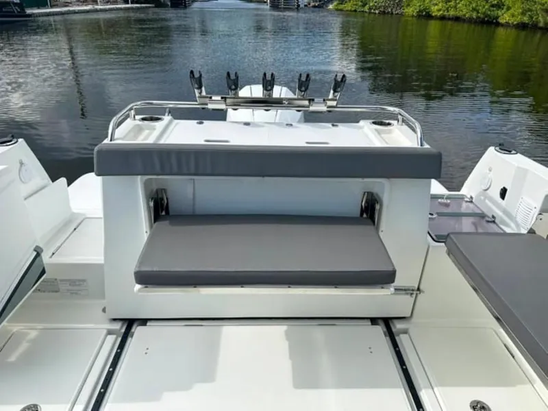 Slide: The Image of 2023 Beneteau Antares 8 boat with cushioned seating, docked on calm water. - 14