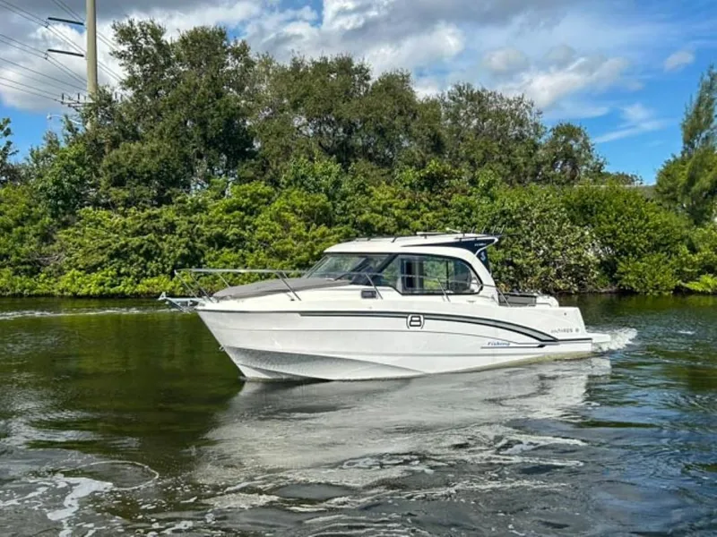Slide: The Image of 2023 Beneteau Antares 8 cruising on a scenic river with lush greenery. - 2