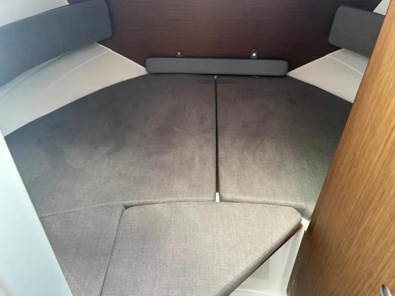 Slide: The Image of Interior cabin of 2023 Beneteau Antares 8 with gray cushions and wood accents. - 8