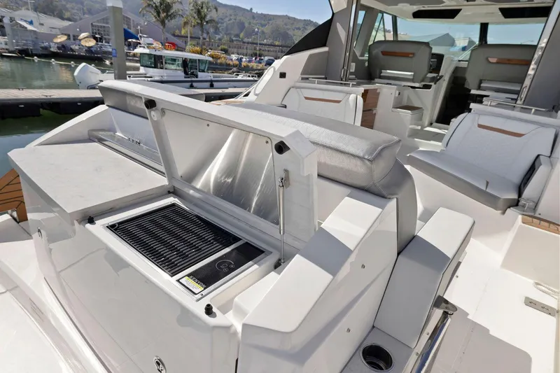 Slide: The Image of 2022 Tiara Yachts 43 LE interior with seating and built-in grill at marina. - 12