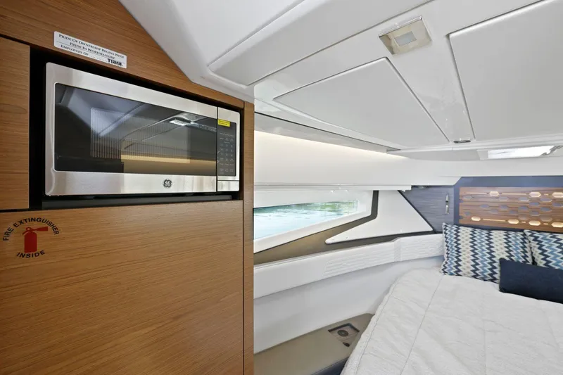 Slide: The Image of 2022 Tiara Yachts 43 LE interior with microwave and cozy cabin bed. - 28