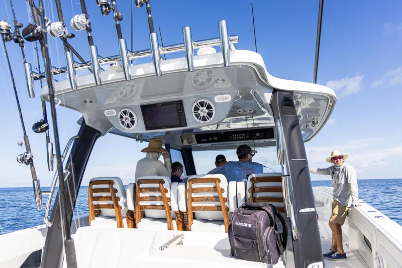 Slide: The Image of 2024 Aquila 47 Molokai boat with passengers, fishing rods, and ocean view. - 18