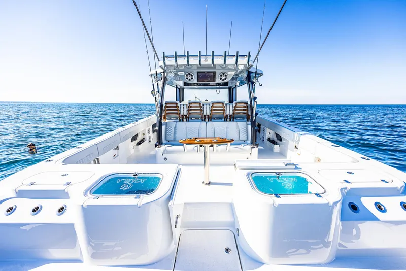Slide: The Image of 2024 Aquila 47 Molokai boat on open sea, spacious deck, clear blue sky. - 21