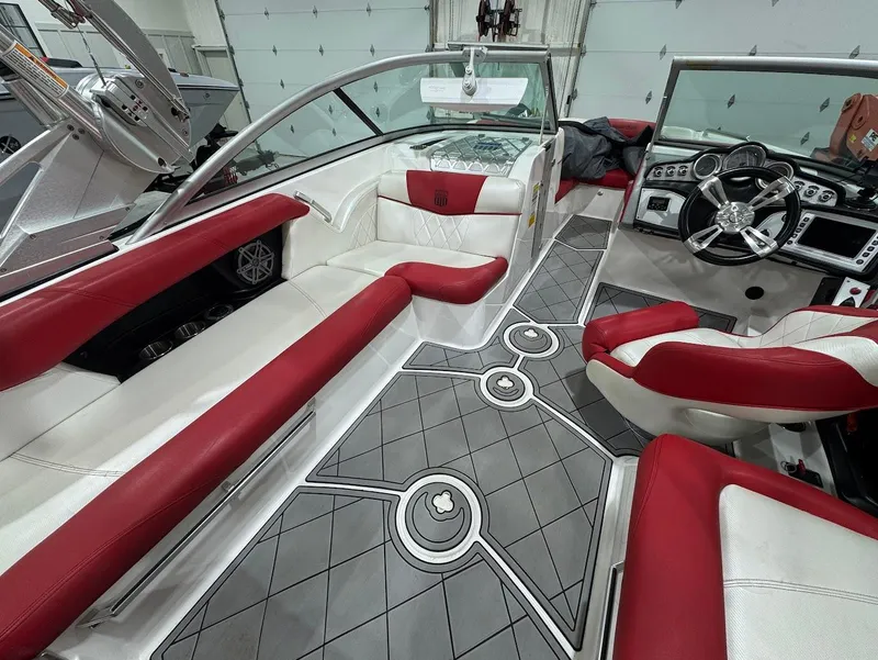 Slide: The Image of 2013 MasterCraft X30 boat interior with red and white seating, modern dashboard, and stylish flooring. - 10