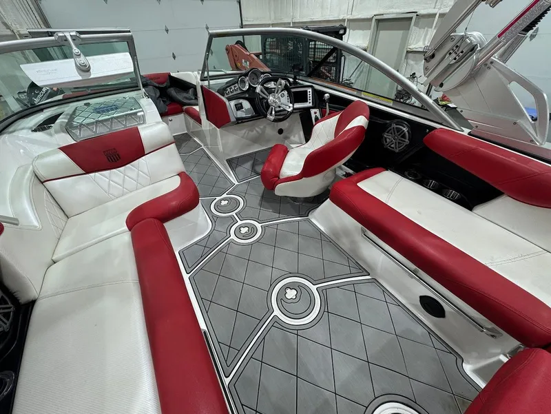 Slide: The Image of 2013 MasterCraft X30 boat interior with red and white seating, modern dashboard, and stylish flooring. - 11