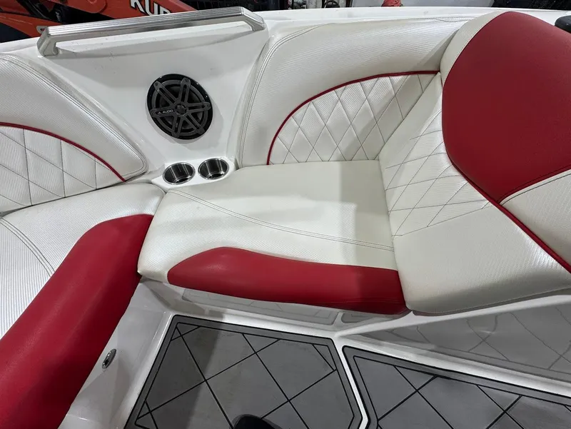 Slide: The Image of 2013 MasterCraft X30 interior with red and white seating, speaker, and cup holders. - 20