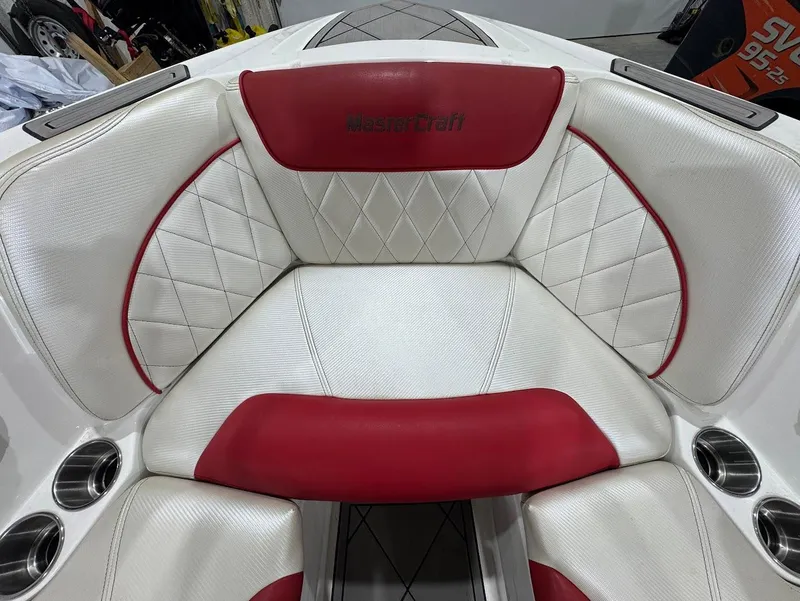 Slide: The Image of 2013 MasterCraft X30 boat interior with red and white upholstery, diamond stitching, and cup holders. - 22