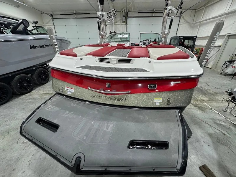 Slide: The Image of 2013 MasterCraft X30 boat with red and white seating in a garage setting. - 3