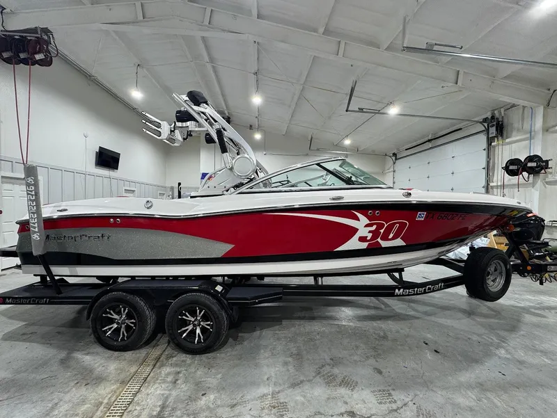 Slide: The Image of 2013 MasterCraft X30 boat with red and white design in a garage. - 5