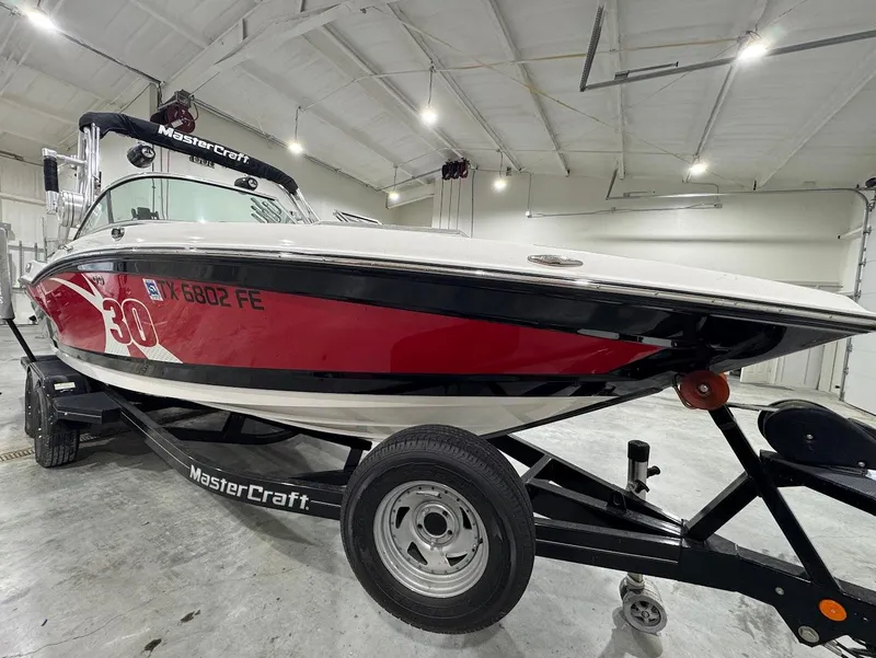 Slide: The Image of 2013 MasterCraft X30 boat on trailer in indoor storage facility. - 6