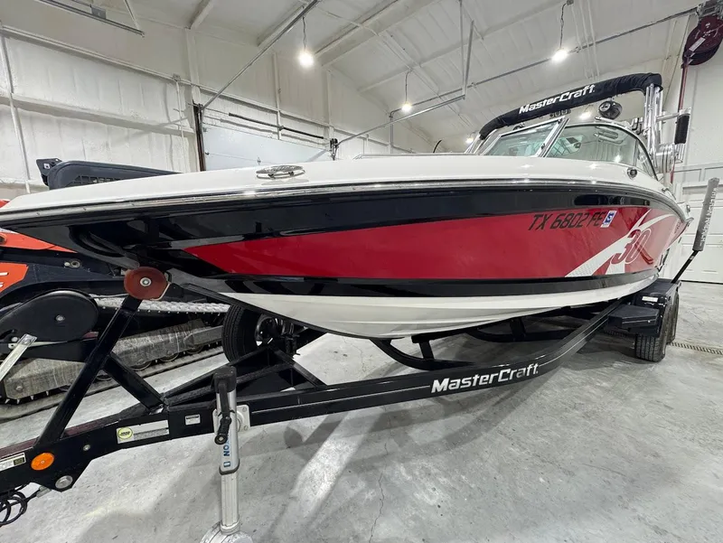 Slide: The Image of 2013 MasterCraft X30 boat in a garage, red and white design on trailer. - 7