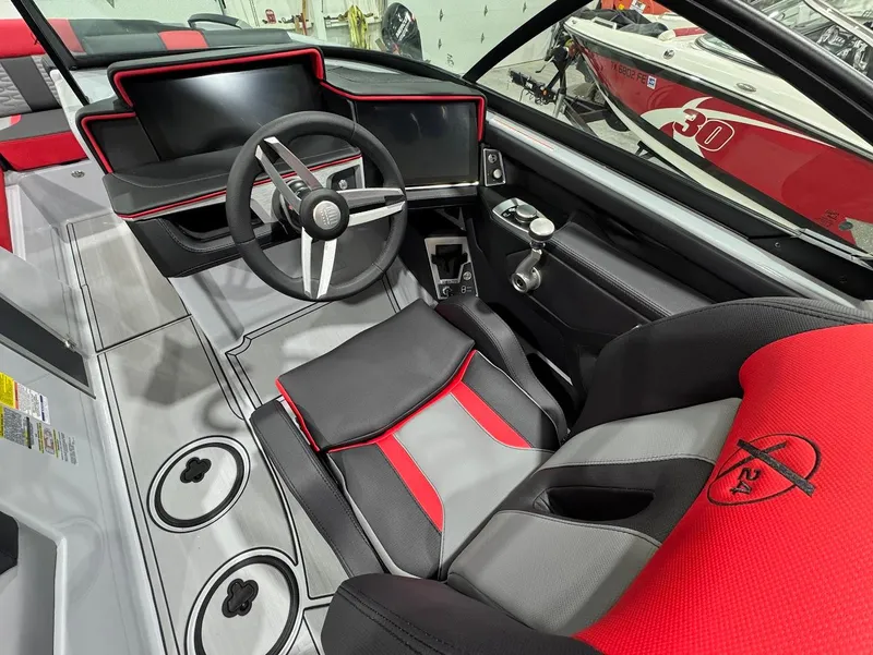 Slide: The Image of 2025 MasterCraft X24 boat interior with sleek black and red design, modern dashboard, and steering wheel. - 11