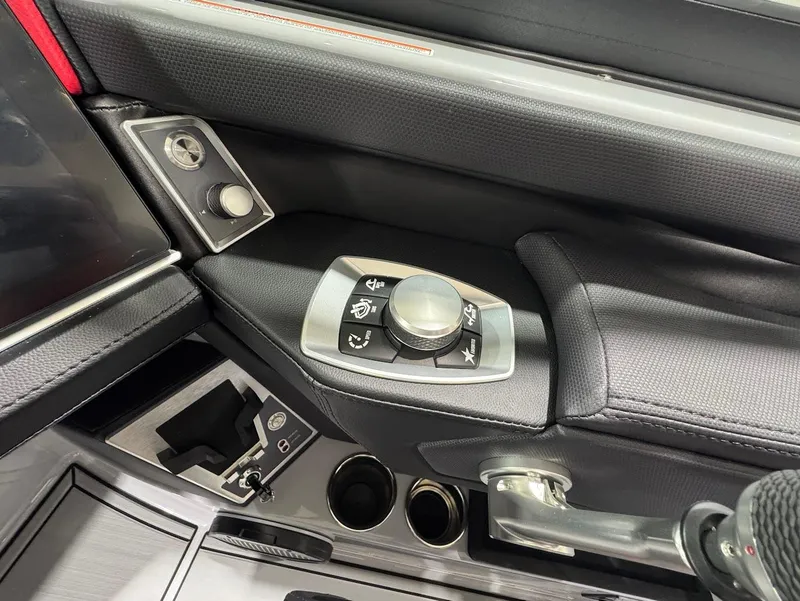 Slide: The Image of 2025 MasterCraft X24 boat control panel with modern joystick and cup holders. - 13