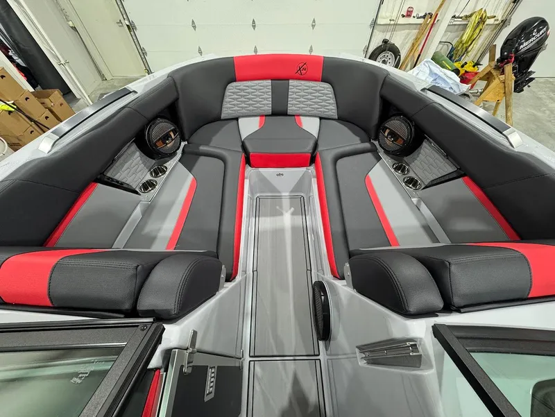 Slide: The Image of 2025 MasterCraft X24 boat interior with red and gray seating, premium audio system. - 14
