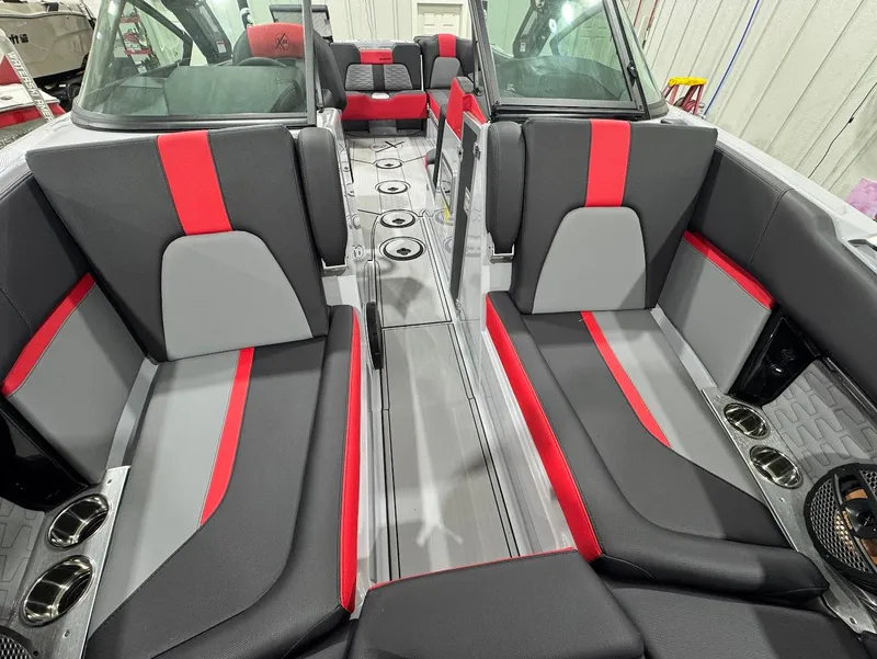 Slide: The Image of 2025 MasterCraft X24 boat interior with red and gray seating, cup holders, and sleek design. - 15