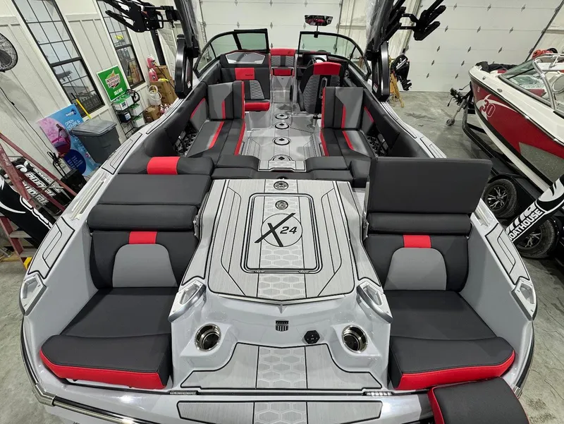 Slide: The Image of 2025 MasterCraft X24 boat interior with sleek gray and red seating, spacious layout. - 7