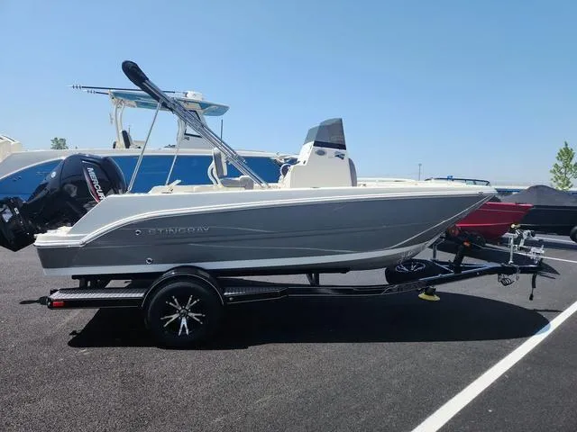 Slide: The Image of 2023 Stingray 173 CC boat on trailer, parked outdoors under clear sky. - 1