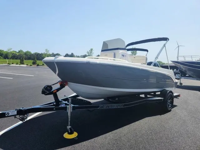 Slide: The Image of 2023 Stingray 173 CC boat on trailer in sunny parking lot. - 2