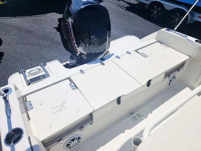 Slide: The Image of 2023 Stingray 173 CC boat deck with storage compartments and outboard motor. - 21