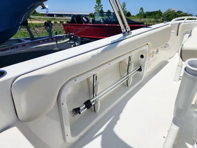 Slide: The Image of 2023 Stingray 173 CC boat interior with storage compartment and rod holder. - 26