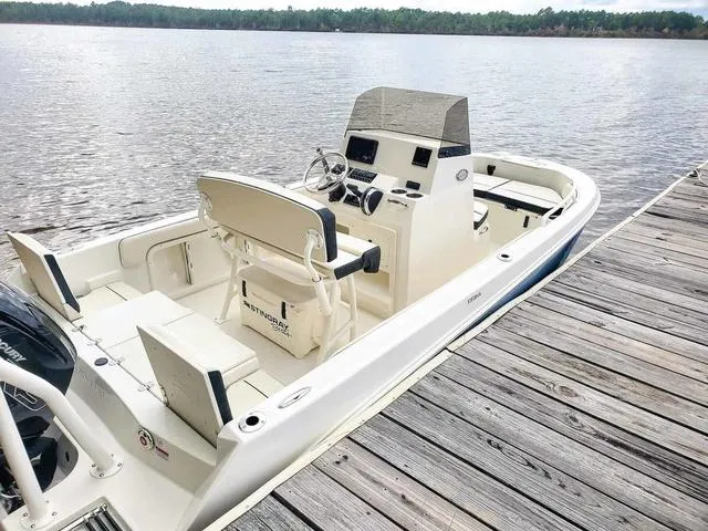 Slide: The Image of 2023 Stingray 173 CC boat docked by a serene lake. - 34
