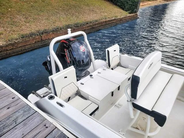 Slide: The Image of 2023 Stingray 173 CC boat docked by the water, featuring a sleek outboard motor. - 35