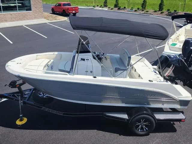 Slide: The Image of 2023 Stingray 173 CC boat with canopy on trailer in parking lot. - 4