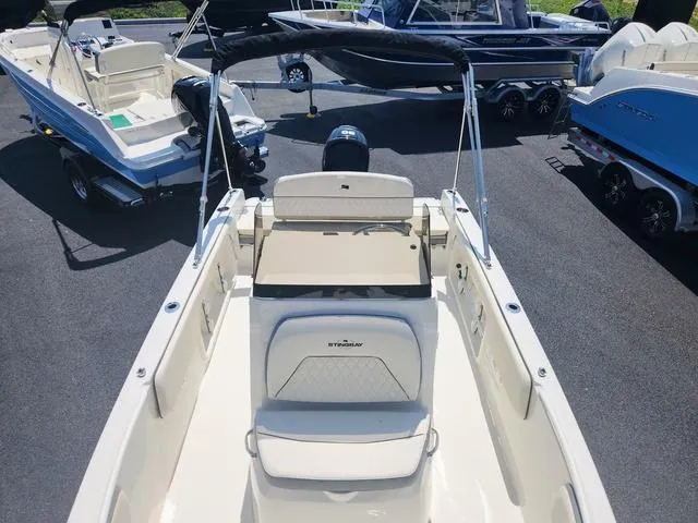 Slide: The Image of 2023 Stingray 173 CC boat interior with seating and steering wheel, displayed outdoors. - 8