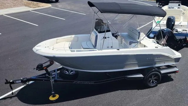 Slide: The Image of 2023 Stingray 173 CC boat on trailer with canopy in parking lot. - 9