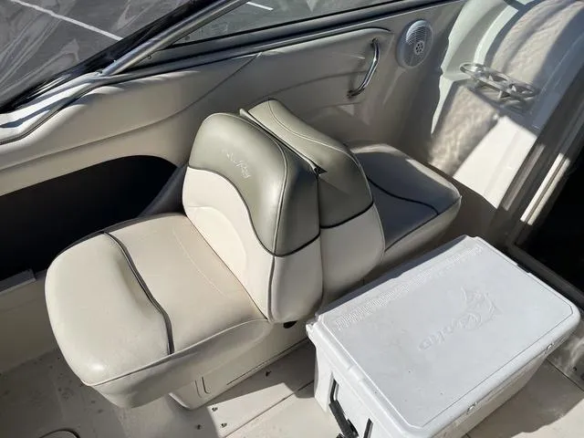 Slide: The Image of 2005 Sea Ray 225 Weekender interior with beige seating and cooler. - 13