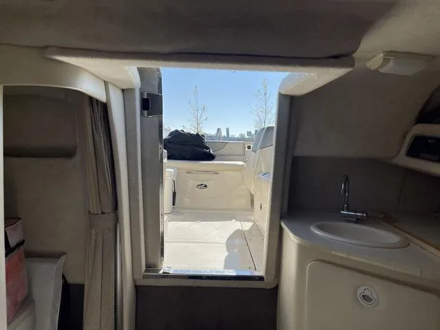 Slide: The Image of Interior view of 2005 Sea Ray 225 Weekender boat, featuring cabin and sink area. - 26