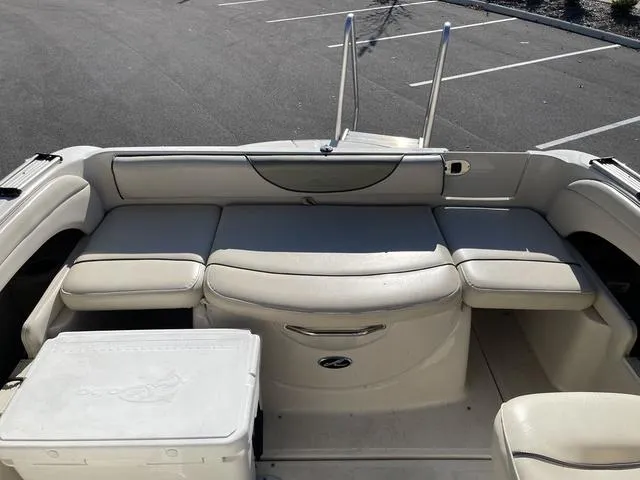 Slide: The Image of 2005 Sea Ray 225 Weekender boat interior with cushioned seating and cooler. - 29