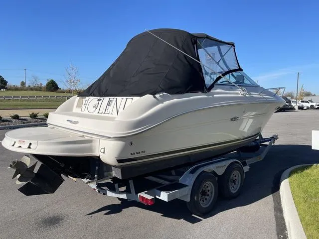 Slide: The Image of 2005 Sea Ray 225 Weekender boat on trailer, black canopy, parked outdoors. - 4