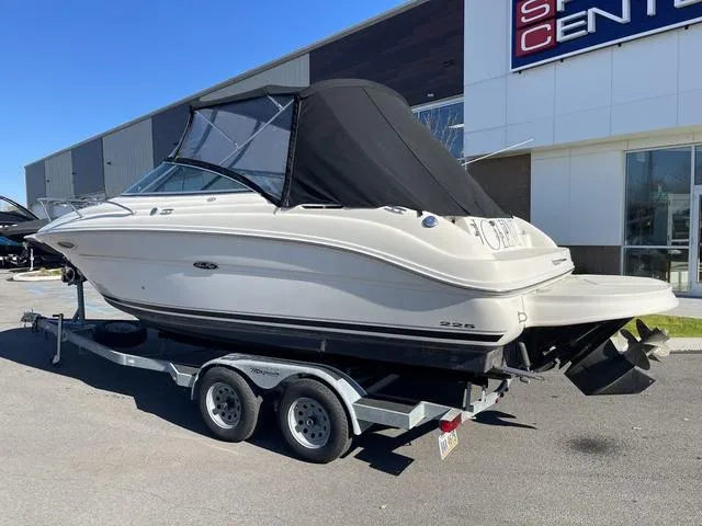 Slide: The Image of 2005 Sea Ray 225 Weekender boat on trailer outside dealership. - 6