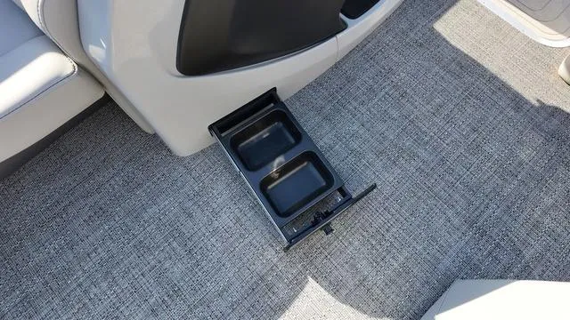 Slide: The Image of 2024 Barletta Cabrio C24UE boat interior with retractable cup holder on carpeted floor. - 15