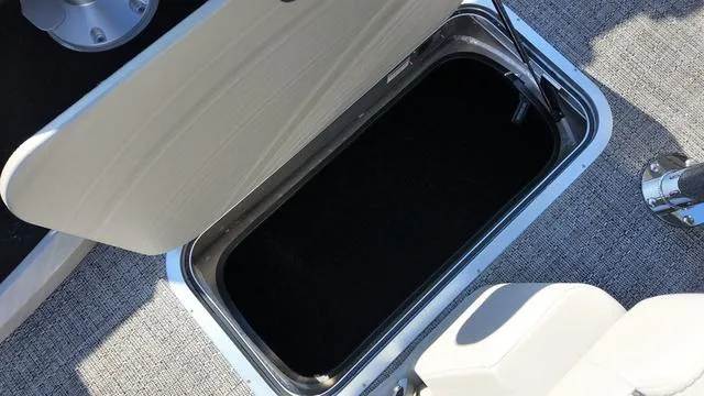 Slide: The Image of 2024 Barletta Cabrio C24UE boat storage compartment with open lid, showcasing interior space. - 18